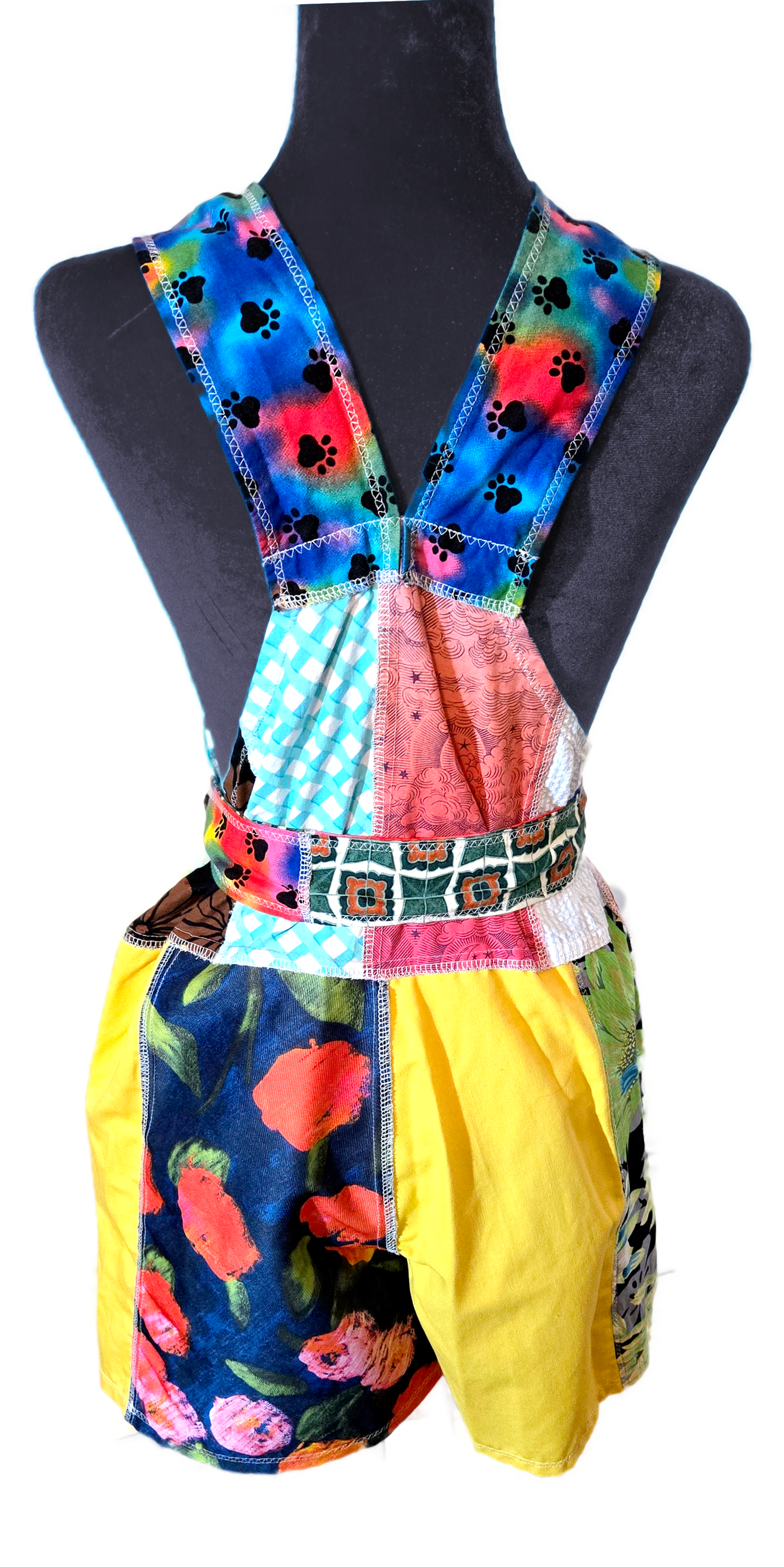 Back view of a colorful patchwork romper on a manniquin.