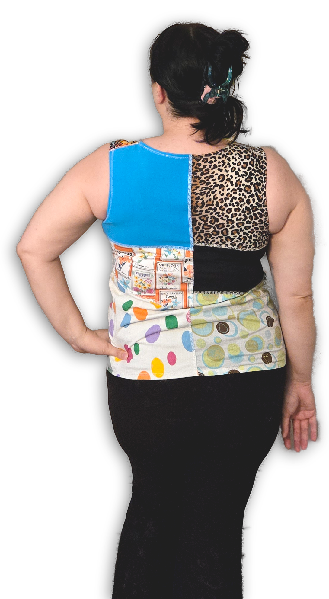 Back view of a person wearing a colorful patchwork top with various patterns on a white background